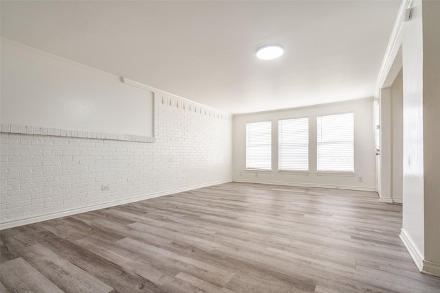 3100 E Park Blvd, Plano, TX 75074 - unfurnished room with brick wall, light wood-type flooring, baseboards, and ornamental molding