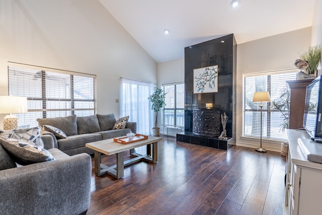 living room with dark wood-style floors, high vaulted ceiling, and recessed lighting