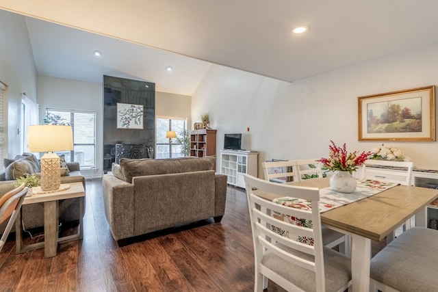 dining space featuring vaulted ceiling, wood finished floors, recessed lighting, and a fireplace