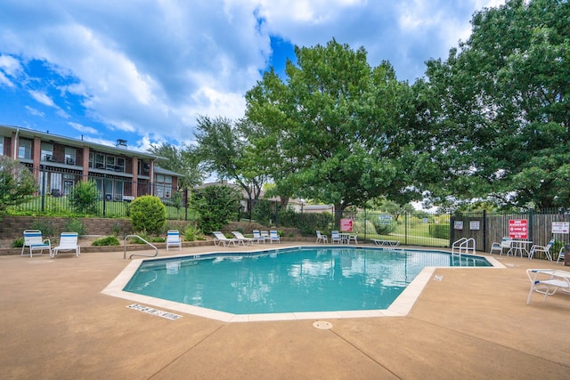 pool featuring fence and a patio