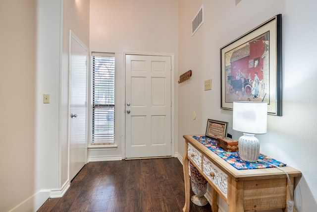 entrance foyer featuring baseboards, visible vents, and dark wood-type flooring