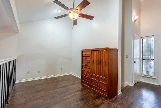 unfurnished room featuring baseboards, a high ceiling, wood finished floors, and ceiling fan