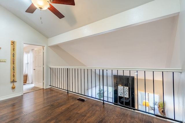 hall featuring a healthy amount of sunlight, vaulted ceiling, and wood finished floors