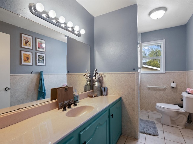 1306 Hulme St, Bowie, TX 76230 - bathroom with a wainscoted wall, toilet, vanity, tile patterned flooring, and tile walls