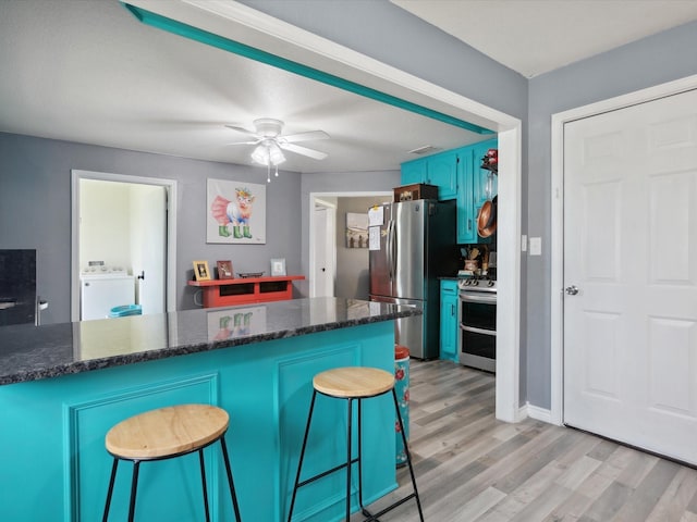 1306 Hulme St, Bowie, TX 76230 - kitchen with a kitchen bar, washer / clothes dryer, stainless steel appliances, light wood-style floors, and ceiling fan