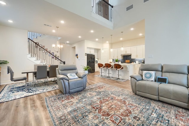 living room featuring stairs, visible vents, and light wood-style floors