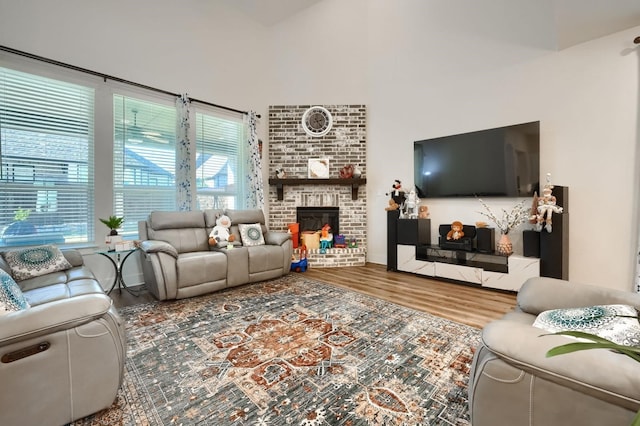 living room with a high ceiling, a fireplace, and wood finished floors