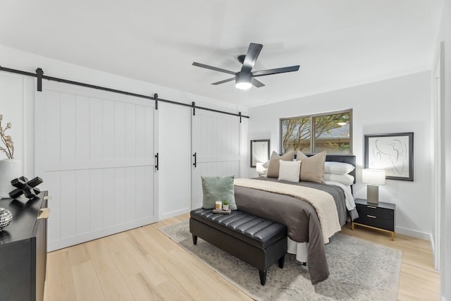 9056 Berkshire Dr, Frisco, TX 75033 - bedroom with a barn door, light wood-style floors, and ceiling fan