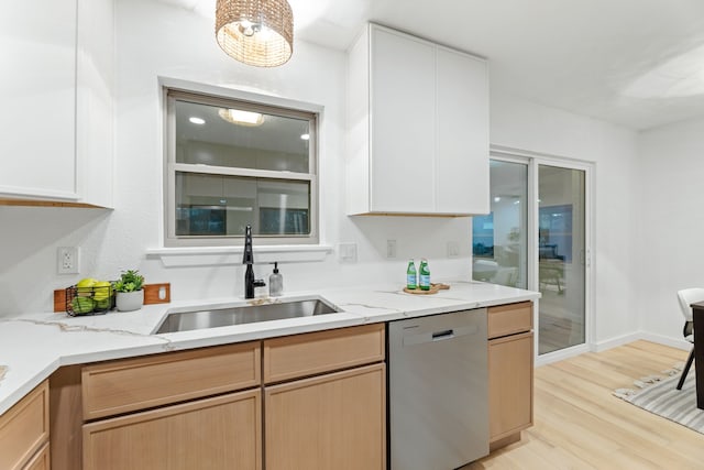 9056 Berkshire Dr, Frisco, TX 75033 - kitchen with stainless steel dishwasher, a sink, light wood-style flooring, light stone counters, and white cabinetry