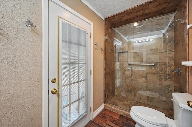 5413 Jerri Ln, Haltom City, TX 76117 - bathroom featuring toilet, a stall shower, wood finished floors, baseboards, and a textured wall