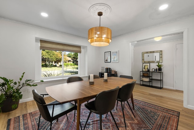 dining space featuring baseboards, recessed lighting, wood finished floors, and ornamental molding