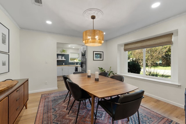 dining space featuring crown molding, recessed lighting, baseboards, light wood-style floors, and visible vents