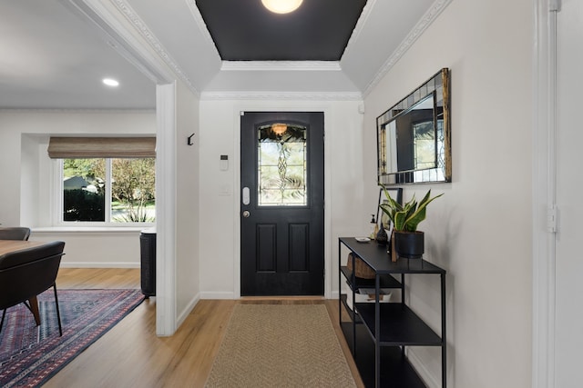 entrance foyer featuring crown molding, baseboards, and light wood finished floors