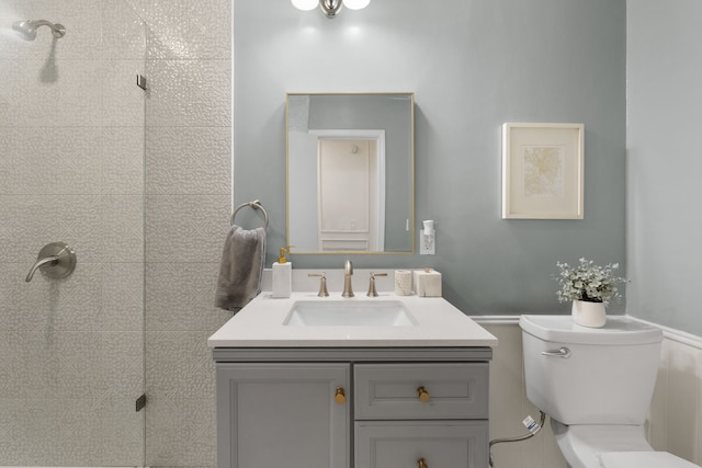 full bath with a tile shower, toilet, and vanity