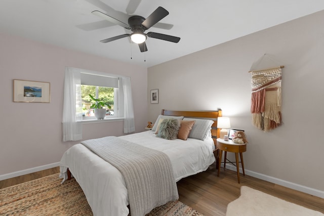 bedroom with baseboards, ceiling fan, and wood finished floors