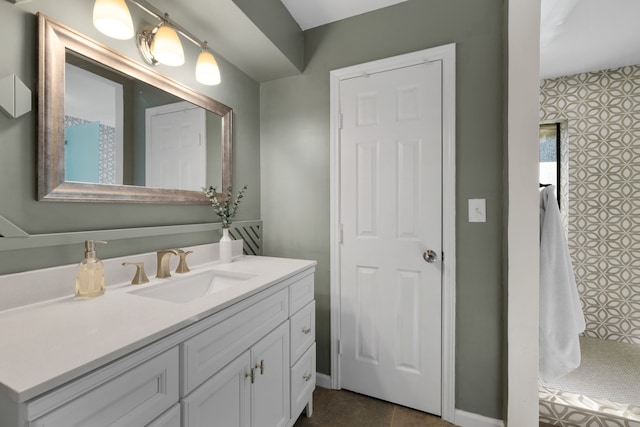 bathroom with a tile shower and vanity