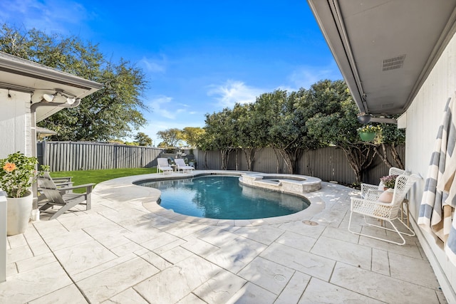 view of pool with a fenced backyard, a pool with connected hot tub, and a patio area