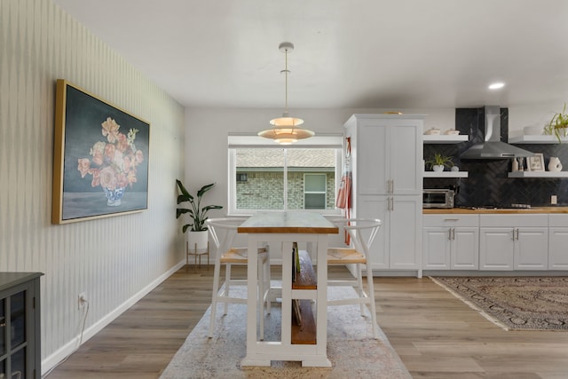 dining area featuring baseboards, a toaster, and light wood finished floors