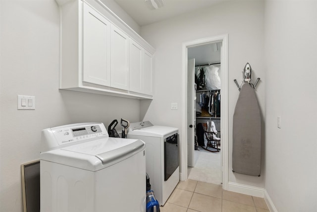2602 Cypress Dr, Rockwall, TX 75087 - washroom featuring washing machine and clothes dryer, baseboards, light tile patterned floors, and cabinet space