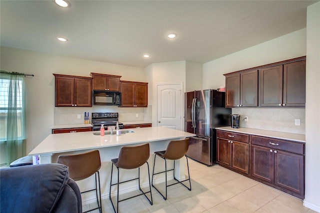 914 Edgar St, Greenville, TX 75401 - kitchen featuring black appliances, a breakfast bar, light countertops, and tasteful backsplash