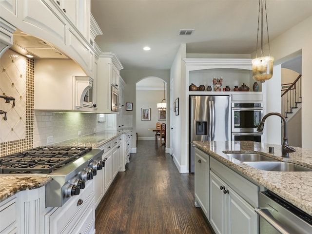 kitchen featuring visible vents, arched walkways, a sink, white cabinetry, and stainless steel appliances