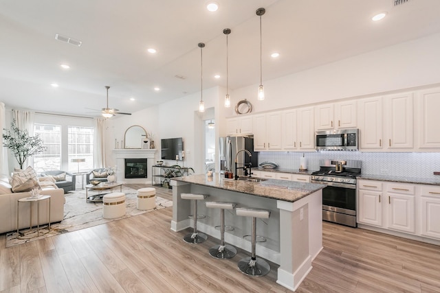5404 Fairdale Dr, Denton, TX 76207 - kitchen with stainless steel appliances, a sink, ceiling fan, a breakfast bar, and open floor plan