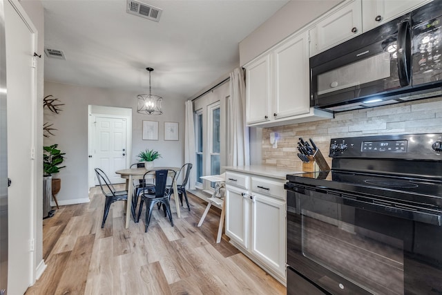 kitchen with visible vents, black appliances, light wood-style flooring, and white cabinets