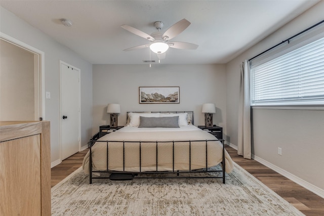 bedroom with baseboards, visible vents, wood finished floors, and a ceiling fan
