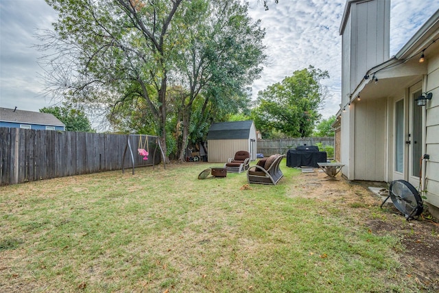 view of yard featuring an outdoor structure, a fenced backyard, and a storage shed