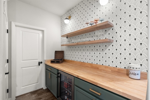 kitchen with green cabinetry, wine cooler, wooden counters, dark wood finished floors, and wallpapered walls