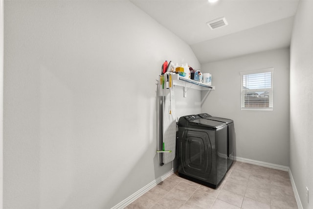 laundry room featuring baseboards, washing machine and clothes dryer, light tile patterned flooring, visible vents, and laundry area
