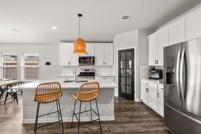 kitchen with dark wood-style floors, visible vents, light countertops, and stainless steel appliances