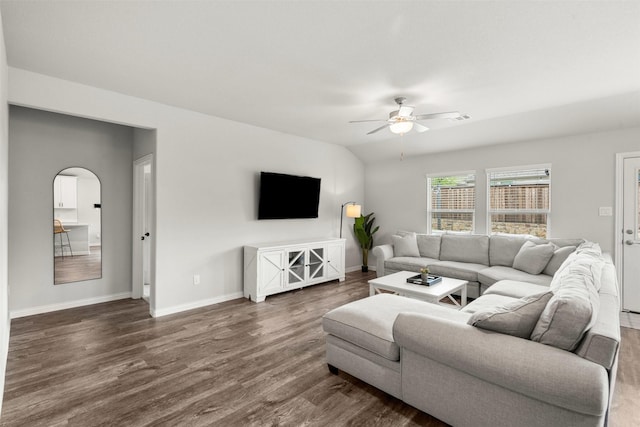 living area with baseboards, ceiling fan, dark wood finished floors, arched walkways, and lofted ceiling