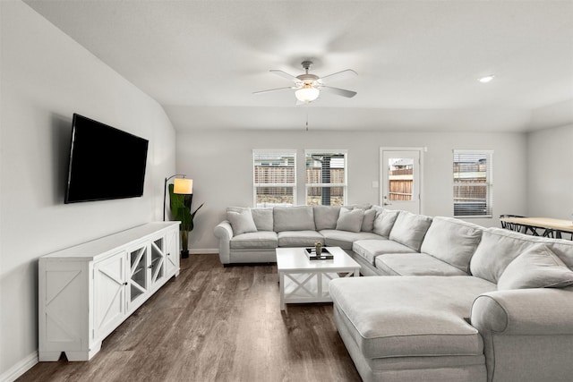 living room with baseboards, dark wood-style flooring, and ceiling fan