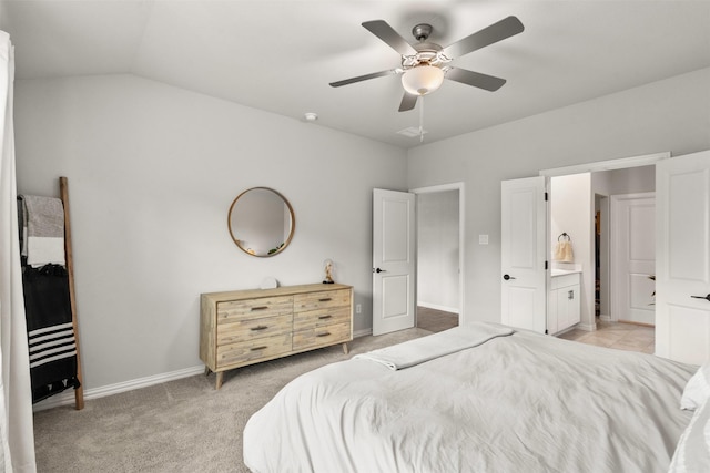 bedroom with baseboards, ceiling fan, ensuite bath, vaulted ceiling, and light colored carpet