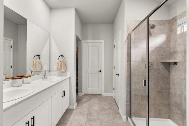 bathroom with tile patterned flooring, a sink, a stall shower, and double vanity