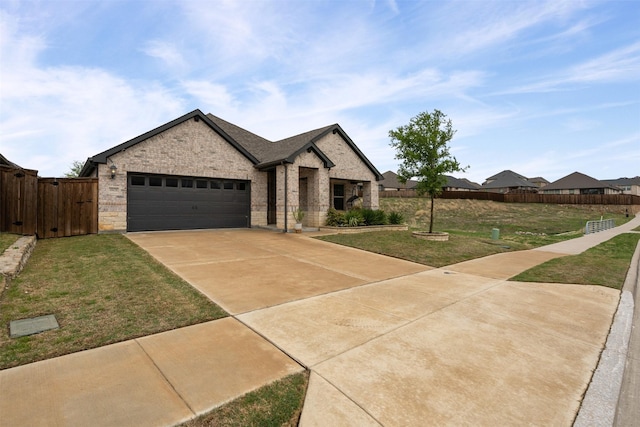 view of front of property featuring driveway, a gate, fence, brick siding, and a front lawn