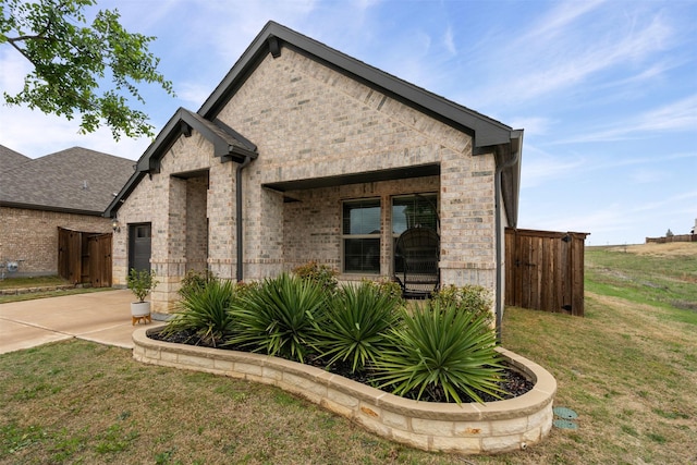 view of front facade with a front lawn, driveway, and brick siding