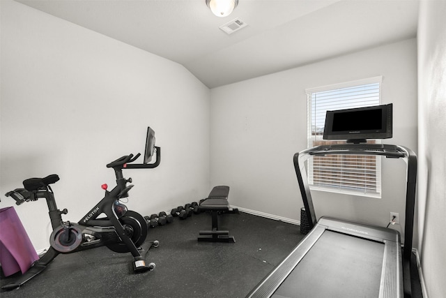 exercise room featuring baseboards, visible vents, and lofted ceiling