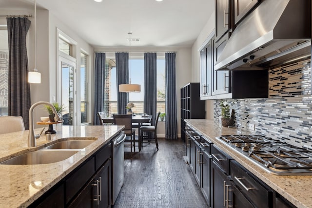 4600 Autumn Sage Dr, Prosper, TX 75078 - kitchen with under cabinet range hood, a sink, stainless steel appliances, tasteful backsplash, and dark wood-style floors