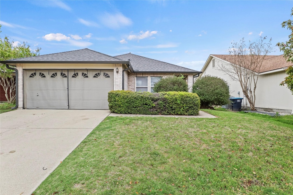 ranch-style home featuring a shingled roof, driveway, a front lawn, and an attached garage