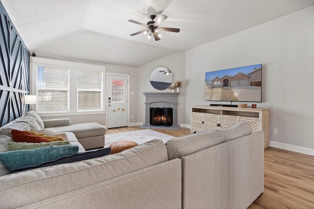 3968 Hunter Peak Rd, Fort Worth, TX 76262 - living area with a ceiling fan, light wood-type flooring, vaulted ceiling, and a lit fireplace