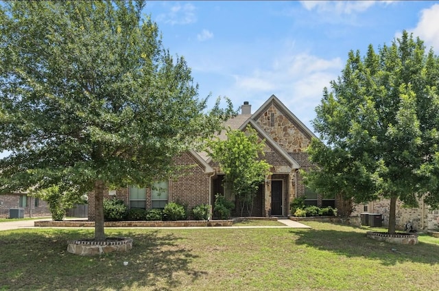 612 Buelwood Ct, Desoto, TX 75115 - view of front of property featuring a front yard, brick siding, central AC unit, and a chimney