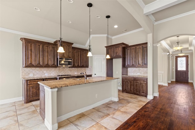 612 Buelwood Ct, Desoto, TX 75115 - kitchen with stainless steel microwave, arched walkways, ornamental molding, backsplash, and light stone counters