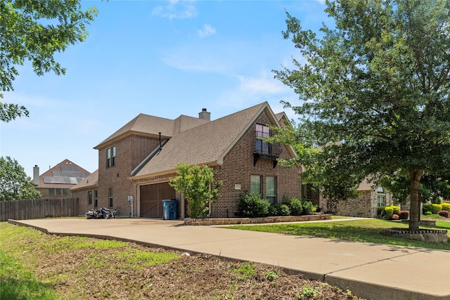 612 Buelwood Ct, Desoto, TX 75115 - view of home's exterior featuring brick siding, an attached garage, a chimney, and concrete driveway
