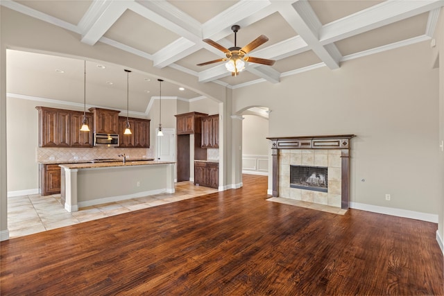 612 Buelwood Ct, Desoto, TX 75115 - unfurnished living room with beam ceiling, ceiling fan, arched walkways, a tiled fireplace, and coffered ceiling