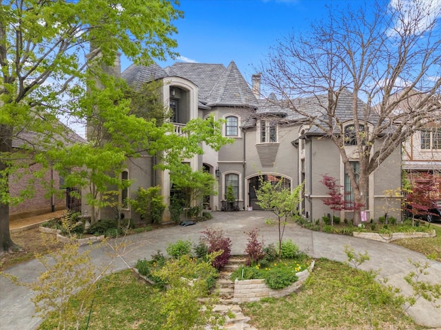 6607 Lake Circle Dr, Dallas, TX 75214 - french country style house featuring a high end roof, curved driveway, stucco siding, and a chimney