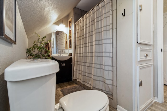 full bathroom with vanity, a textured ceiling, toilet, and wood finished floors