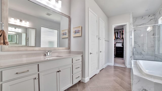 2500 Rosecroft Ct, Celina, TX 75009 - bathroom featuring a marble finish shower, vanity, a bath, a walk in closet, and baseboards