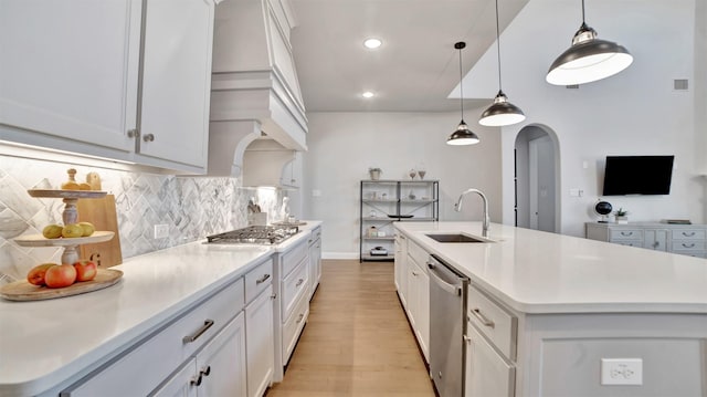 2500 Rosecroft Ct, Celina, TX 75009 - kitchen featuring a sink, light wood-style floors, appliances with stainless steel finishes, arched walkways, and tasteful backsplash